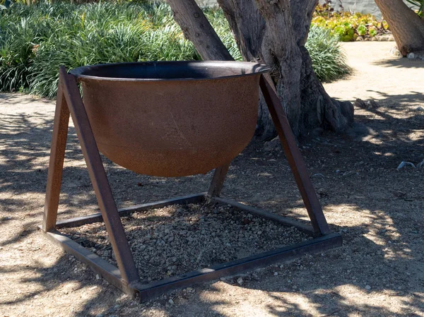 Olla de acero grande y oxidada sentada a la sombra de un lugar soleado —  Fotos de Stock