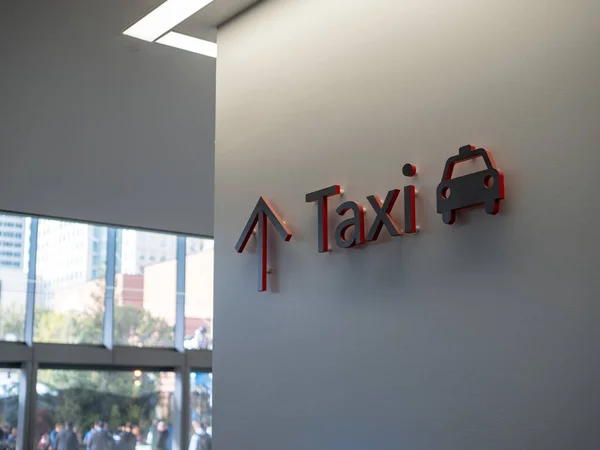 Cartel de taxi rojo y negro colgado en la pared del edificio moderno — Foto de Stock