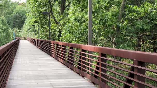 Vue en angle de la passerelle en bois à l'extérieur avec des branches soufflant du vent — Video