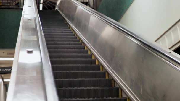 Balas de escada rolante a descer na estação de metro subterrânea — Vídeo de Stock