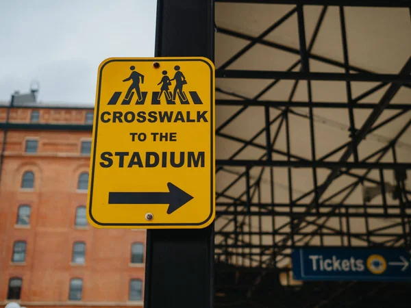 Gelber Zebrastreifen zum Stadionschild, das in der Nähe eines Ballparks nach rechts zeigt — Stockfoto