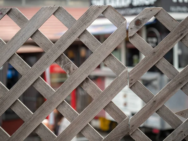 Træ diamant formet hegn stående foran en shopping og spiseplads - Stock-foto