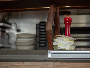 Kase ve bir restoran mutfak tezgahına oturmuş plakaları hizmet ile yığılmış alış irsaliyeleri