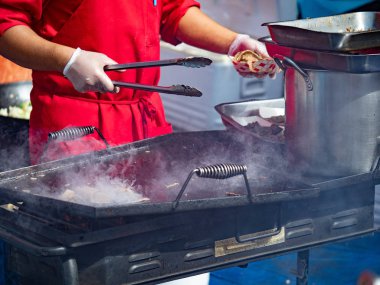Cook zor durumda açık bir endüstriyel Barbekü bir parçası olarak çalışır