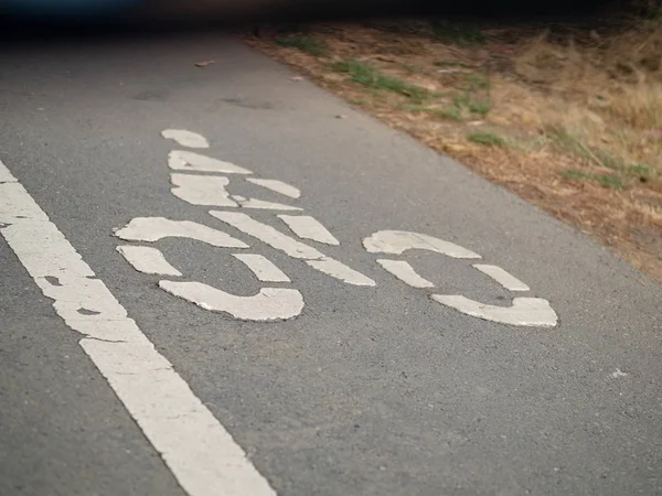 Símbolo de carril bici en la calle asfaltada que conduce a un túnel oscuro — Foto de Stock