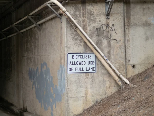 自転車が暗い領域につながる通りのトンネルに掲示される完全な車線記号の使用を許可 — ストック写真