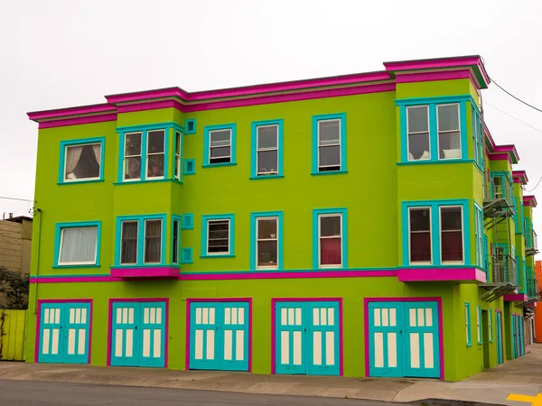 Edificio verde, rosa y verde azulado en el barrio en el cielo nublado — Foto de Stock