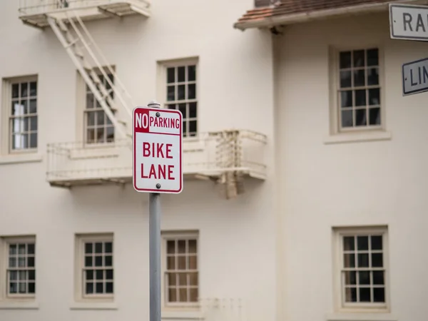 Sem estacionamento, sinal de ciclovia postado na frente do armazém branco — Fotografia de Stock