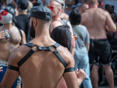 Kaslı erkek siyah deri şapka ve Bdsm koşum takımı ve sakal ile açık Festivali'nde yürür