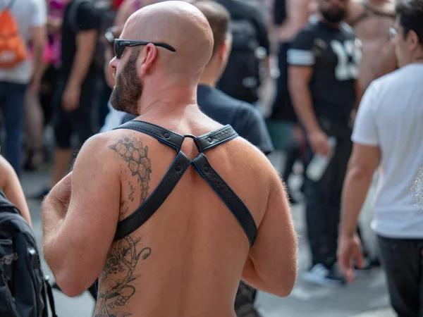 Hombre blanco tatuado en cuero negro arnés BDSM kink camina calle en Folsom Street Fair al aire libre — Foto de Stock