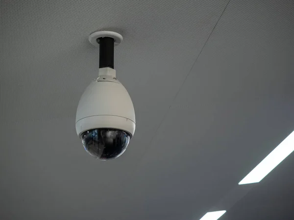 Біла камера кругового спостереження на стелі в громадських місцях, прикріплена до білої стелі — стокове фото