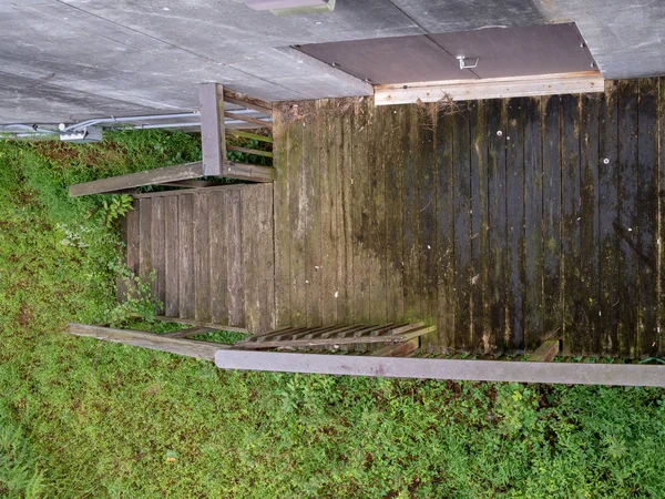 Vista aérea de la pasarela de madera que conduce a la puerta oxidada en la zona boscosa sospechosa — Foto de Stock