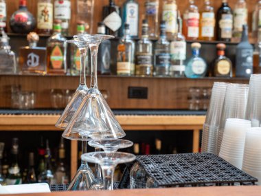 Martini gözlük plastik bardak ve içki ile yoğun bir bar arkasında yığılmış