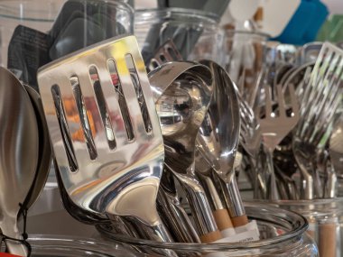 Diğer mutfak eşyaları ile ekranda yansımaları ile Parlak metal spatula