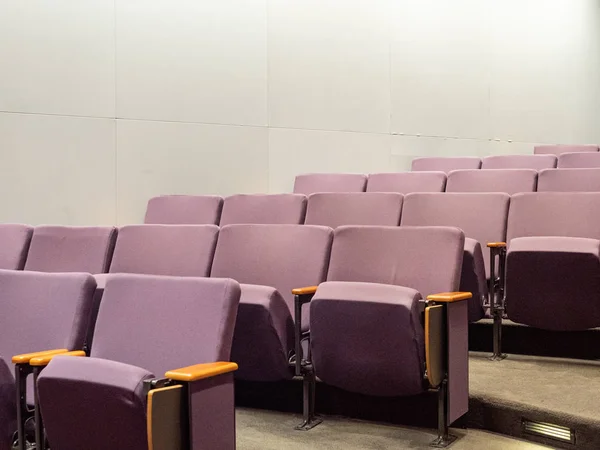 Sillas de estilo teatro púrpura en un pequeño auditorio limpio vacío — Foto de Stock
