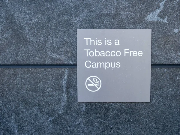 This is a tobacco free campus gray sign and logo posted outside of building