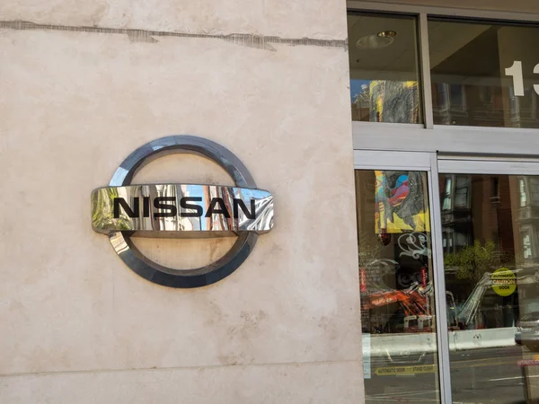 Króm Nissan gépjármű logó és jel kívülállók a forgalmazási bemutatóterem — Stock Fotó