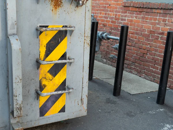 Patrón de cinta de advertencia en el contenedor de residuos exterior al lado del edificio — Foto de Stock