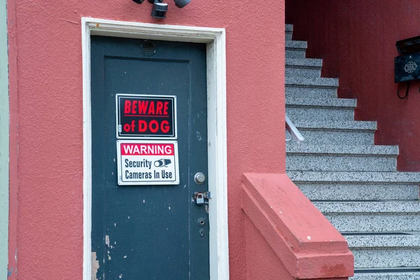 Cuidado con el perro y la cámara de seguridad señal de advertencia delante de la casa cerrada con llave — Foto de Stock