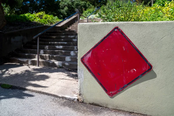 Parka giden merdivenlerin başında beton bariyer üzerinde verim şeklinde kırmızı işaret — Stok fotoğraf