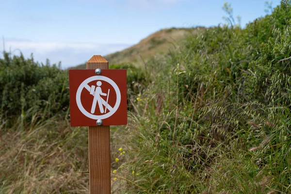 No hiking cross out warning sign in a dangerous area on trail