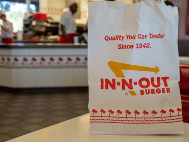 Restoran yerinde oturan in-n-out Burger zincir çanta. Slogan ve logo