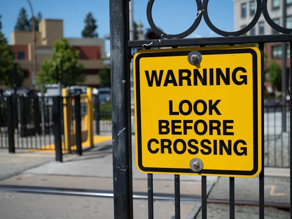 Mirada de advertencia antes de cruzar señal de advertencia amarilla en la estación de tren — Foto de Stock