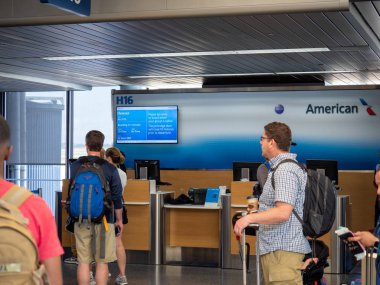 İnsanlar American Airlines ile havaalanında yardım masası check-in yürümek