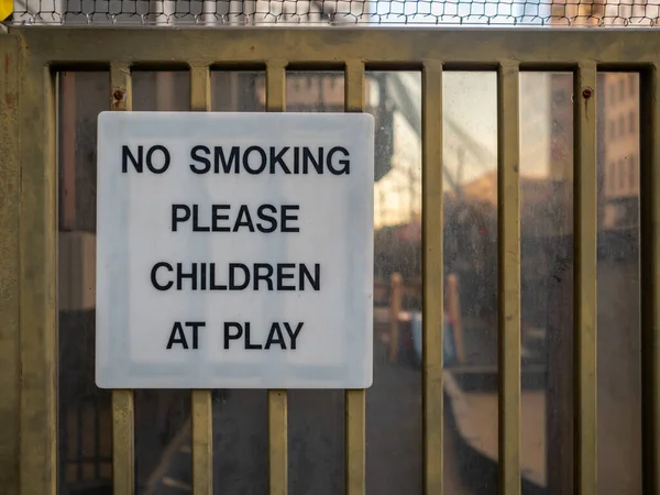 No fumar, por favor, los niños en el letrero de juego publicado en el área de juegos recreativos — Foto de Stock