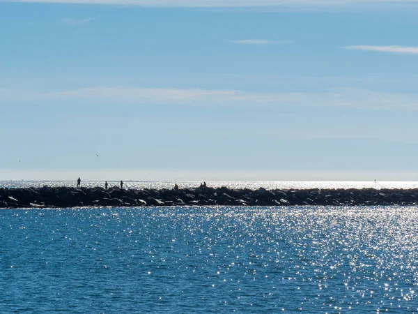 Gente caminando a lo largo del paseo marítimo de roca en la zona de playa turística — Foto de Stock