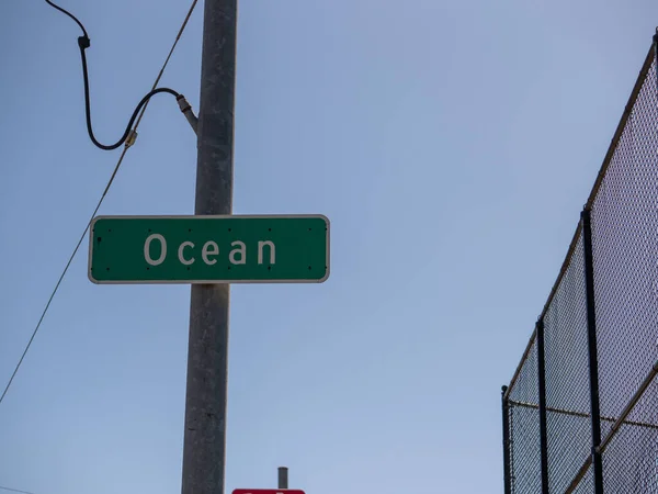 Panneau de rue indiquant l'océan dans le ciel bleu en zone urbaine — Photo