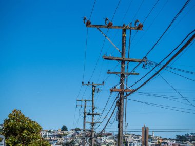 Güneşli bir günde konut binalarına elektrik kabloları bağlayan bir dizi elektrik tesisatı.