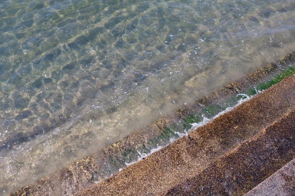 Clean water wave with cement stairs, Crystal clear sea waters and superb clean, See rocks on the bottom of the sea nature ocean, under water in beach clear and clean