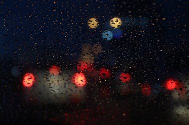 Gece hayatı arka plan bokeh ve yağmur damlası camına bokeh aydınlatma renkli yoğunlaşma bulanık