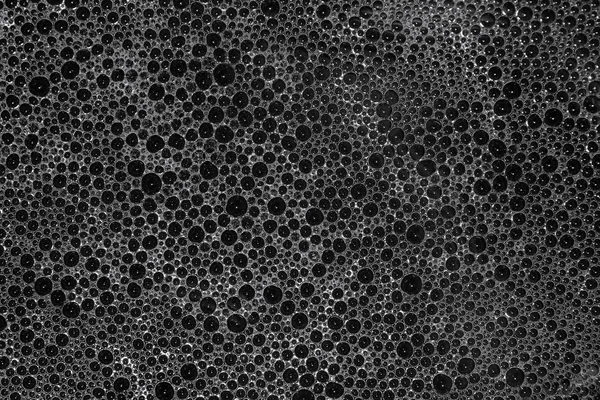 Sponge Bubble detergent on the dirty surface water, Bubble soap white foam on black background, Sponge from washing black background