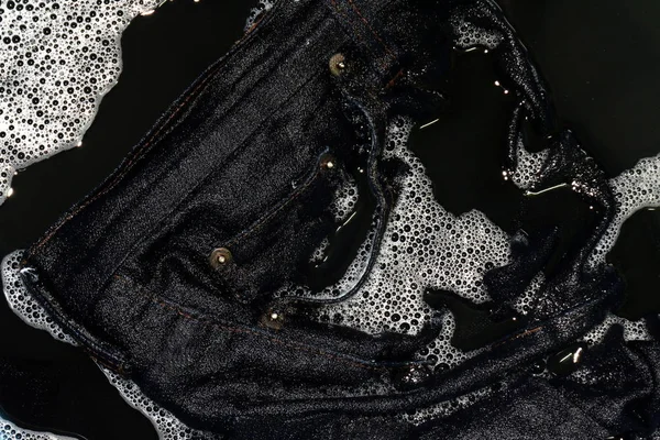 Jeans blue dark soak in sponge washing and wet in sponge water dirty black, Colored jeans clothes