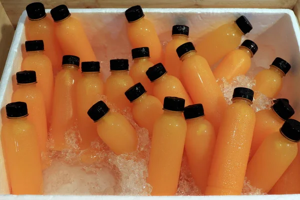 Orange Juice fresh in bottle ice cooler at market street food (Selective Focus)