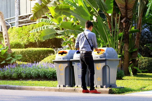 men are dumping plastic bottles waste into trash bin recycle at sideways walk at garden public, bin waste, plastic bin garbage