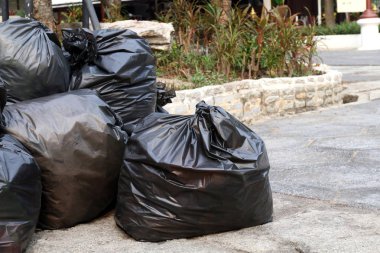 Siyah çanta kat zemin genel park üzerinde yığın çöp atık plastik, çok kazık, birçok siyah çöp plastik torbalar yığın dökümü