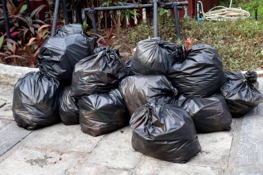 Siyah çanta kat zemin genel park üzerinde yığın çöp atık plastik, çok kazık, birçok siyah çöp plastik torbalar yığın dökümü