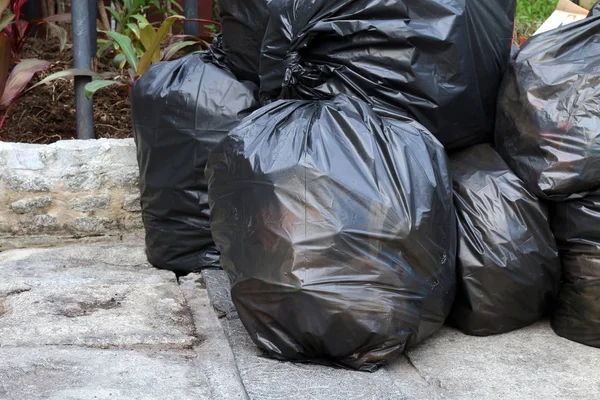 Siyah çanta kat zemin genel park üzerinde yığın çöp atık plastik, çok kazık, birçok siyah çöp plastik torbalar yığın dökümü