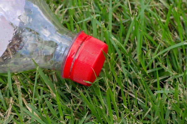 garbage plastic bottles on the grass, bottle plastic clear garbage waste close-up, bottle trash on the lawn and copy space, plastic soft drink bottle waste