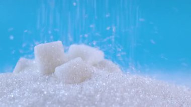 şeker ve beyaz granüllü şeker dökülmesi, aşırı şeker tüketimini, şeker hastalığını ve sağlık risklerini, sağlık farkındalığını, şekerli gıdalar için granüllü şekeri, tatlı içeriğini sembolize eder.