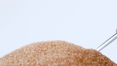 brown sugar, spoon scooping granulated brown sugar, symbolizing excessive sugar consumption, diabetes and health risks, health awareness, sugar for sweetness food, ingredient dessert