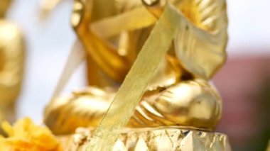 Close-up Golden Buddha statue, public religious art symbolizing peace, spirituality, and Thai cultural heritage