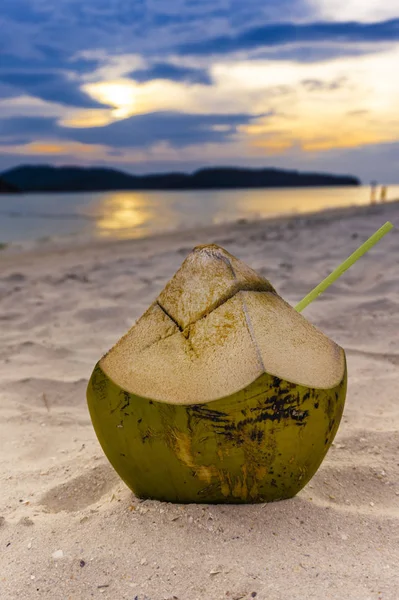 Коктейль Кокосовый сок с соломой лежал на песчаном пляже — стоковое фото