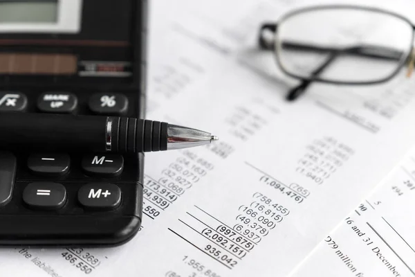 Yatırım ve mali tablo sayfa analizi ve raporlama konsepti ile hesap makinesi, cam ve kalem. odak seçici.