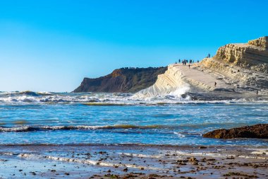Beyaz kayalıklar doğal olarak düz pug Scala dei Turchi Beach insanlarla dolu fırtınalı Akdeniz denize yakın Agrigento, Sicilya, İtalya ile yapılmış