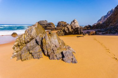 Kumlu Adraga Plajı, Portekiz sahilinin kıyı şeridi üzerinde rock