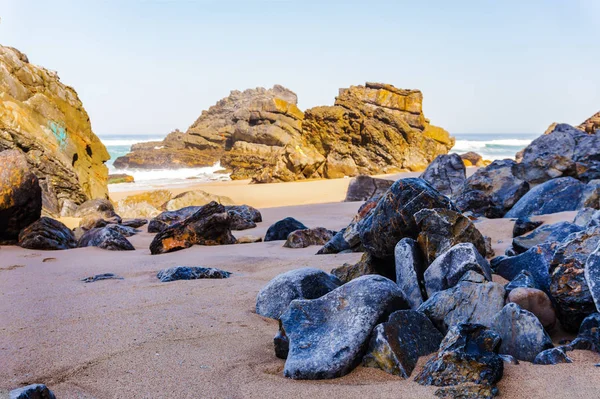 Rocas y piedras en la costa de arena Playa de Adraga — Foto de Stock
